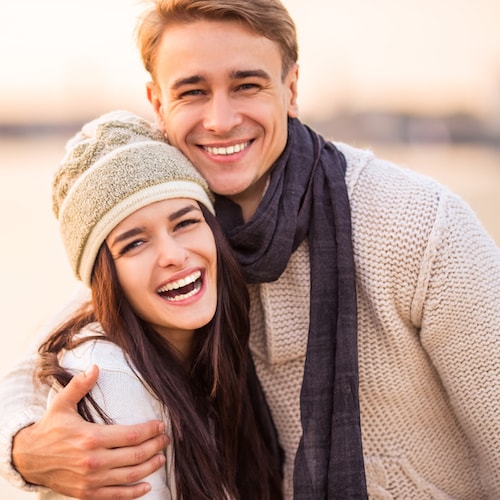Young couple dressed in autumnal clothes, hugging and smiling