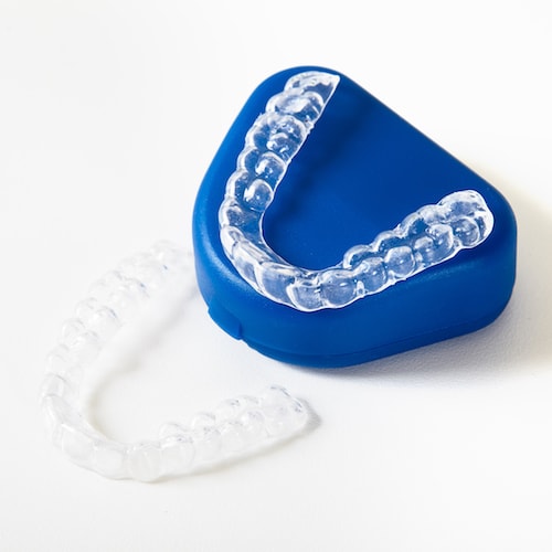 Two sets of Invisalign aligners with the blue case that the aligners arrive in